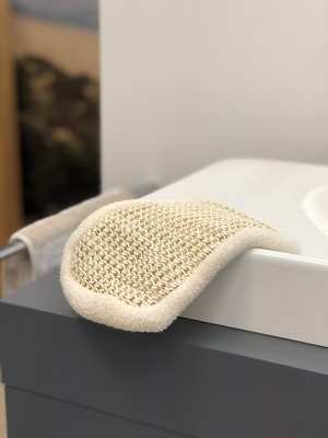 Sisal-Baumwoll-Peelinghandschuh auf Waschbecken im Badezimmer