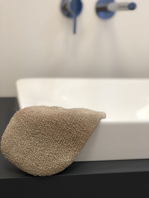 Ionisierender Massagehandschuh mit Kupfer auf dem Waschbecken