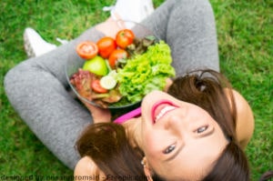 Junge Frau beim Essen von Salat