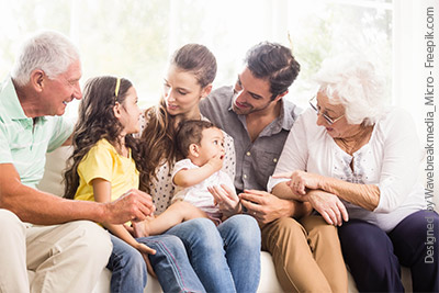 Drei Generationen, die fröhlich beisammen sitzen