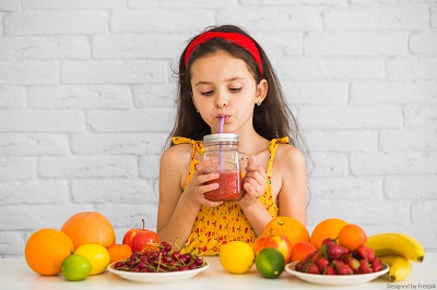 Junges Mädchen mit Obst und Smoothie